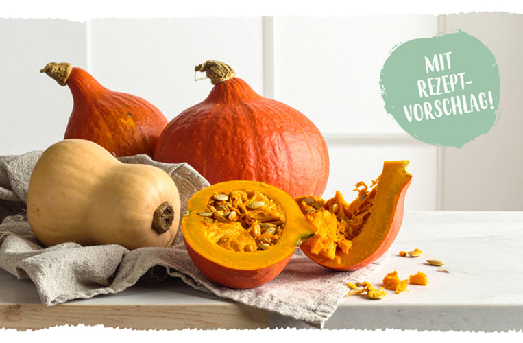 KI generiert: Kürbisse auf einem Tisch, halbiert und ganz. Text: "MIT REZEPTVORSCHLAG!"
