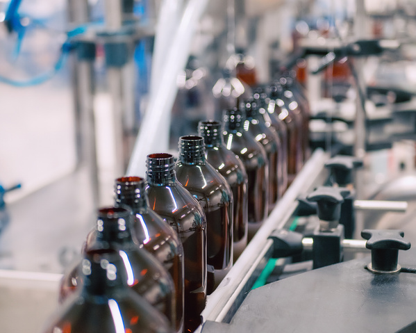 KI generiert: Fließband mit braunen Flaschen in einer Produktionsanlage.