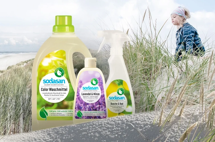 KI generiert: Produkte von Sodasan in Dünenlandschaft; ein Kind im Hintergrund. Text enthält: "Color Waschmittel", "Lavendel & Minze".