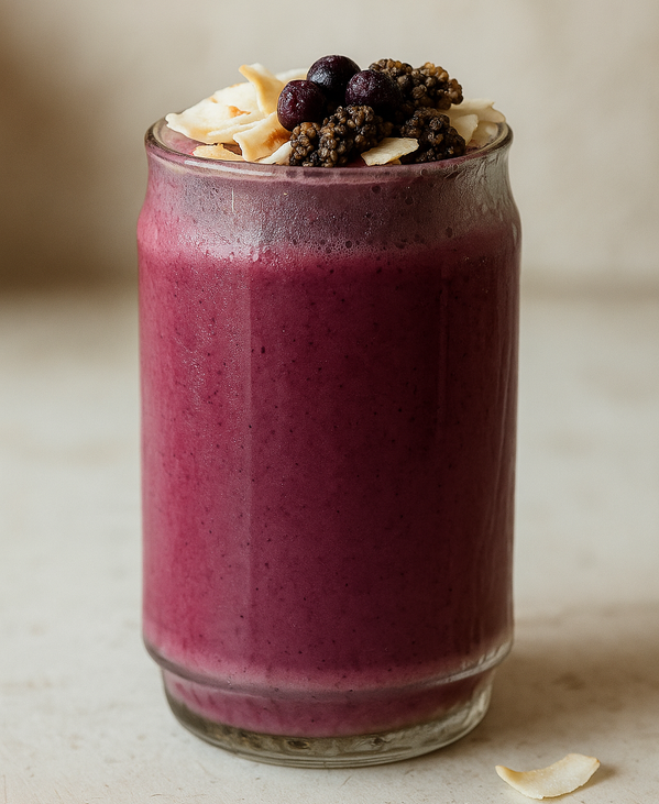 KI generiert: Ein lila Smoothie im Glas, garniert mit Beeren und Kokosraspeln.