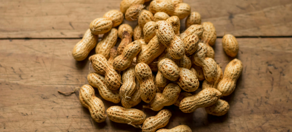 KI generiert: Eine Ansammlung von Erdnüssen auf einem Holztisch.