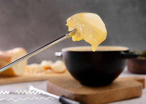 KI generiert: Ein Löffel mit geschmolzenem Käse über einer Fondue-Schale.