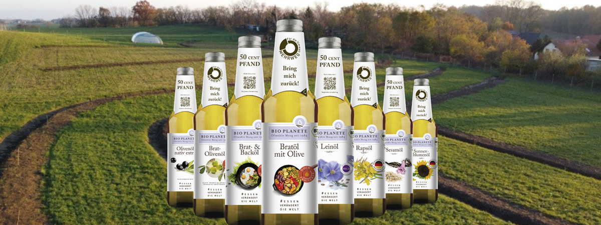 KI generiert: Flaschen mit Bio-Ölen auf einem Feld platziert. Text: "Bio Planète", "50 Cent Pfand", "Brings mich zurück!".