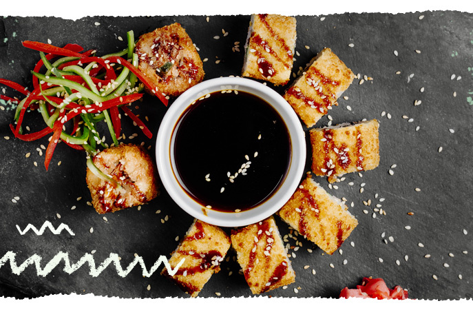 Schälchen mit Sojasauce und asiatischem  Essend rumherum